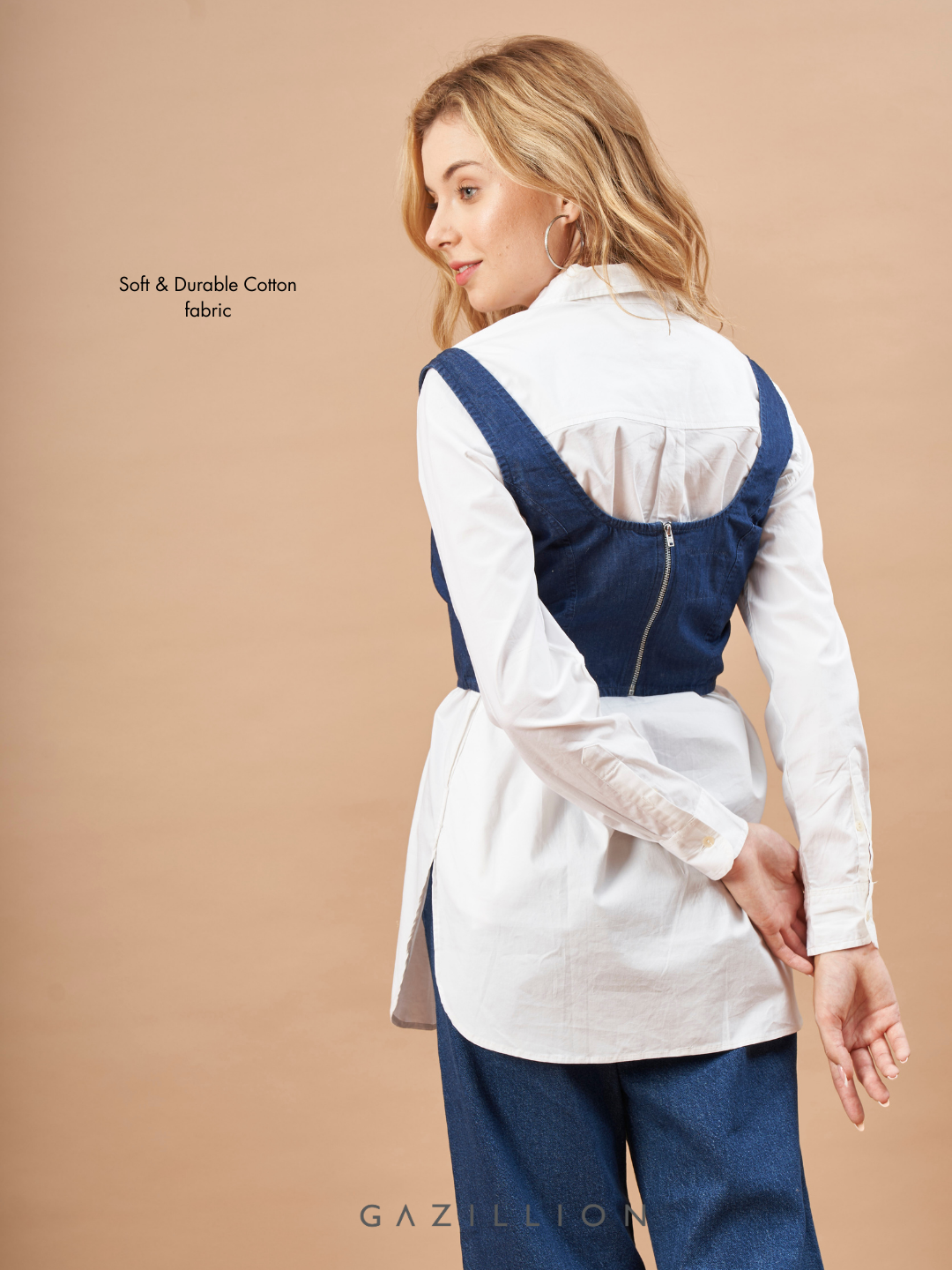 Woman wearing a white shirt with a navy vest on a beige background.