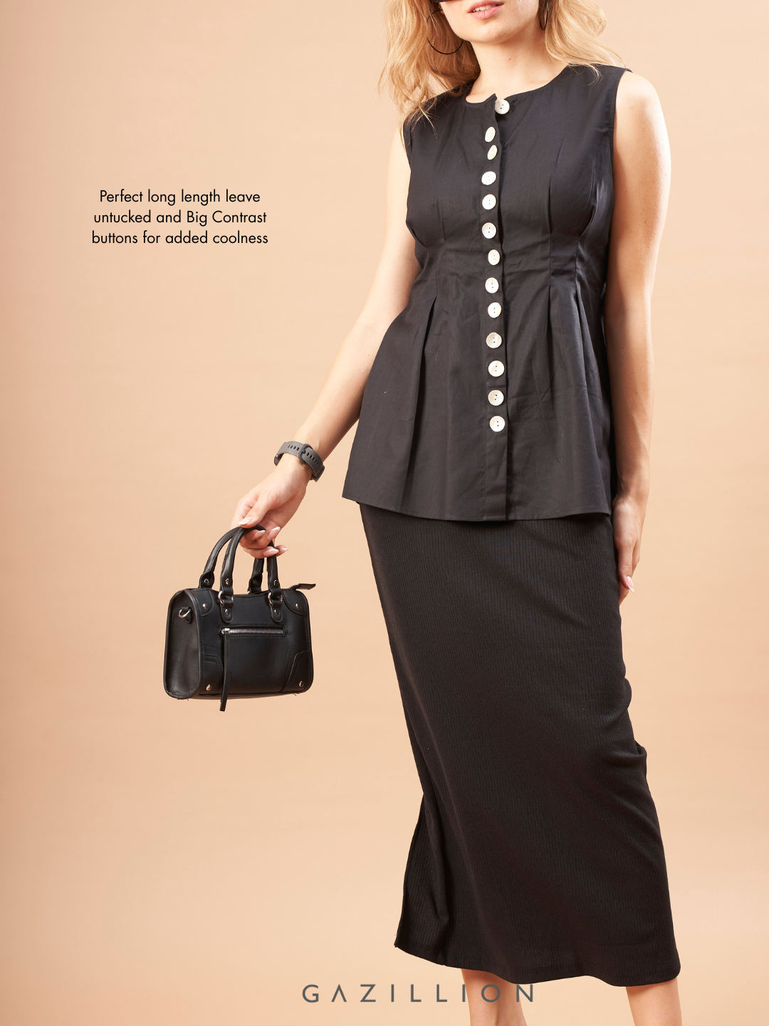 Woman wearing a black sleeveless top with buttons and black skirt, holding a black handbag on a beige background.