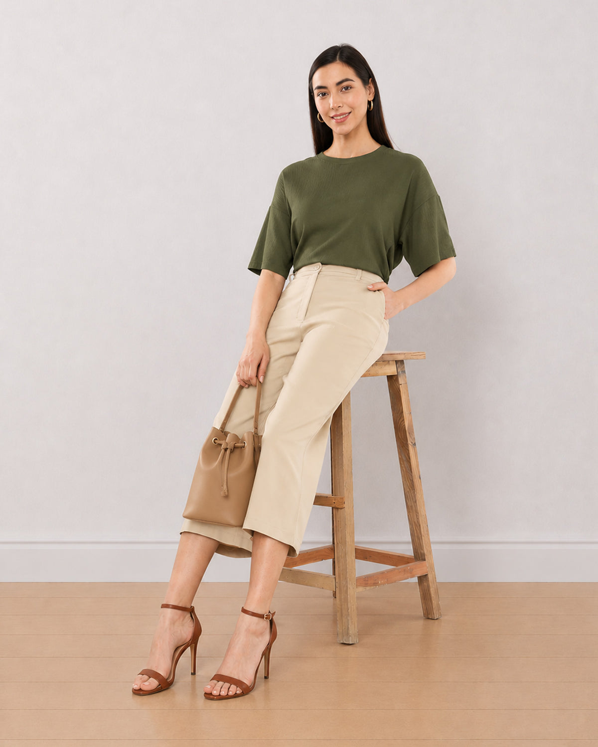 Bella beige 3/4th straight pants, seated angled view with loose fit and mid calf hem