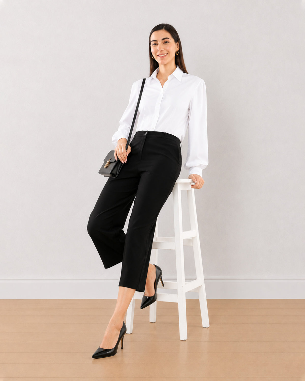 Bella black loose fit 3/4th straight pants, seated angled view with mid calf length