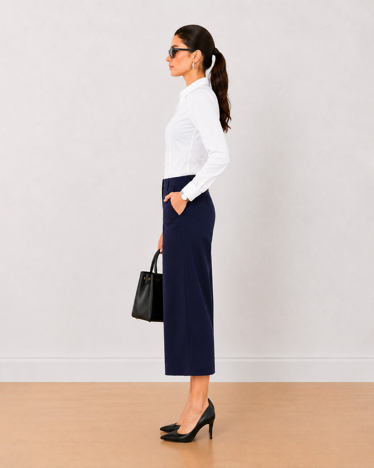 Bella navy blue medium waist 3/4th straight pants, side view with the mid calf hem
