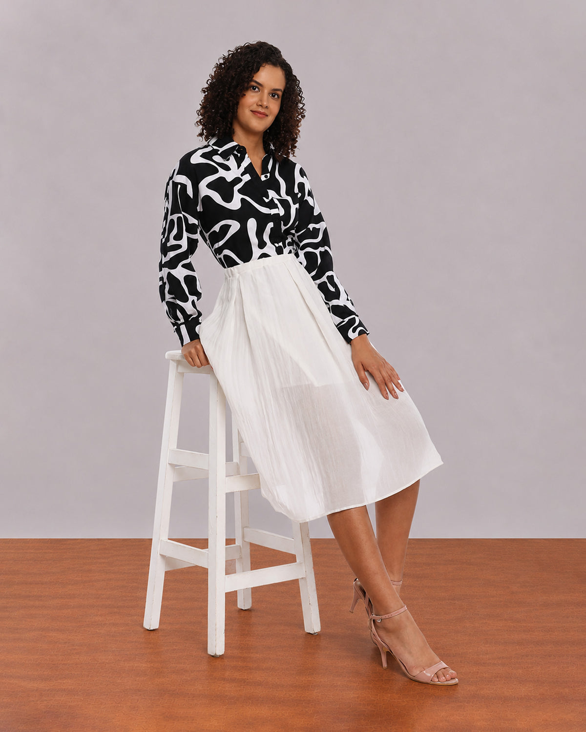 Brooke black and white abstract print shirt, seated angled view with full sleeves
