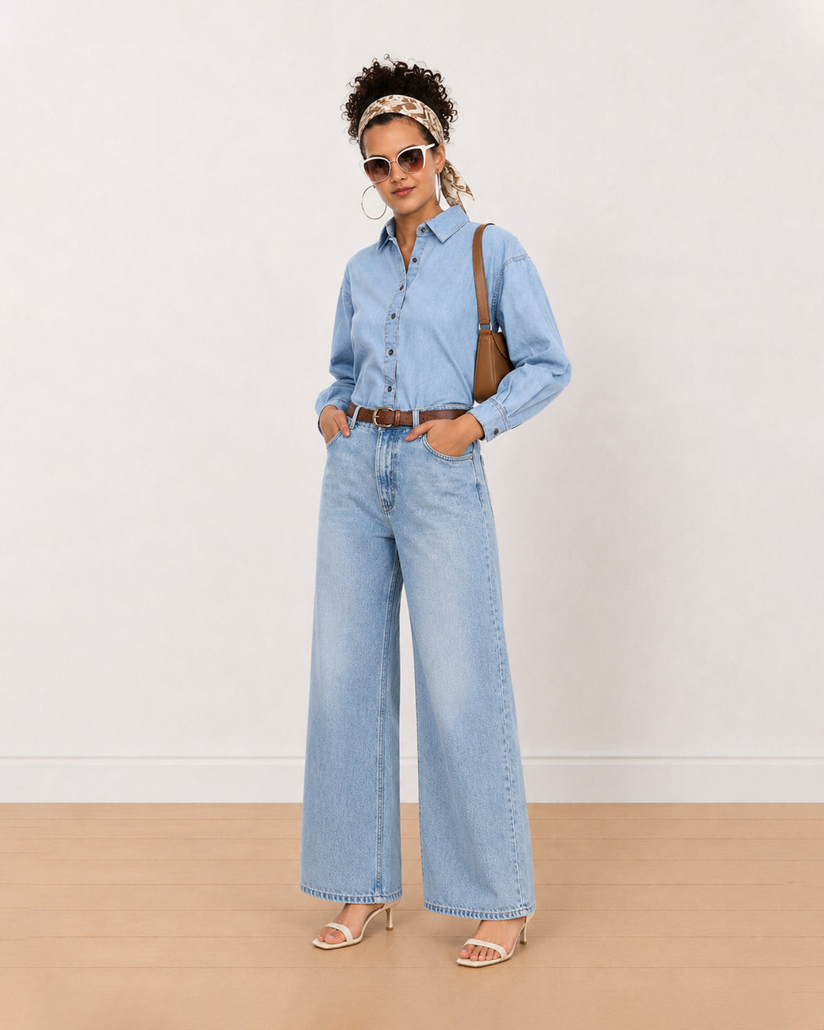 Brynn light blue denim shirt worn loose, front view with the curved frayed hem