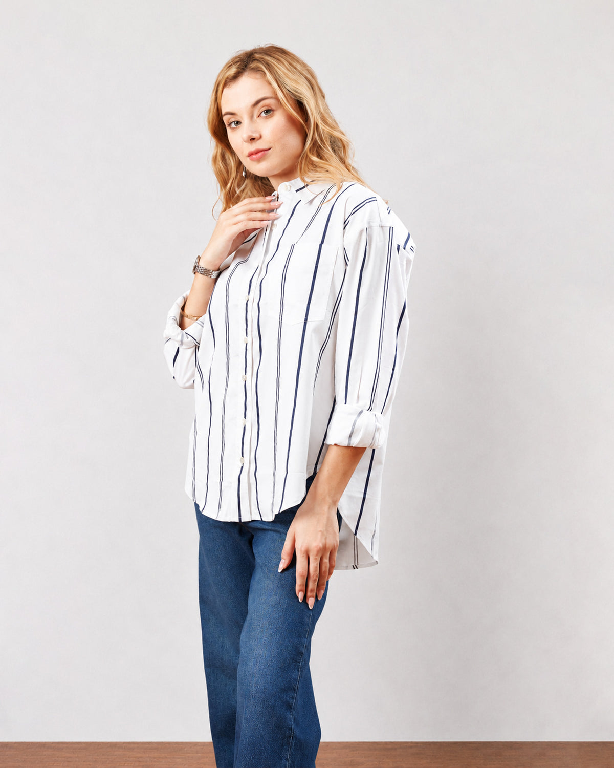 Darlina white striped cotton oversized shirt with full sleeves and buttoned cuffs, angled front view