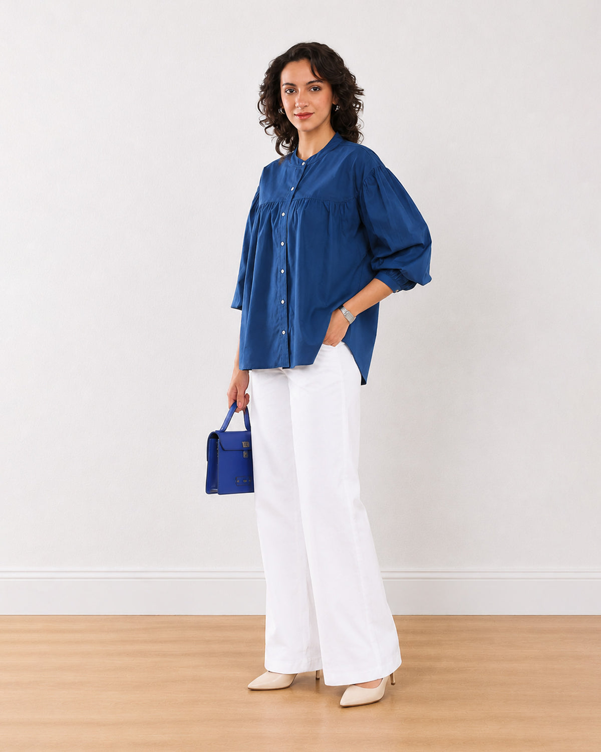 Ellie dark blue cotton shirt with a curved hem and 3/4 puff sleeves, angled front view