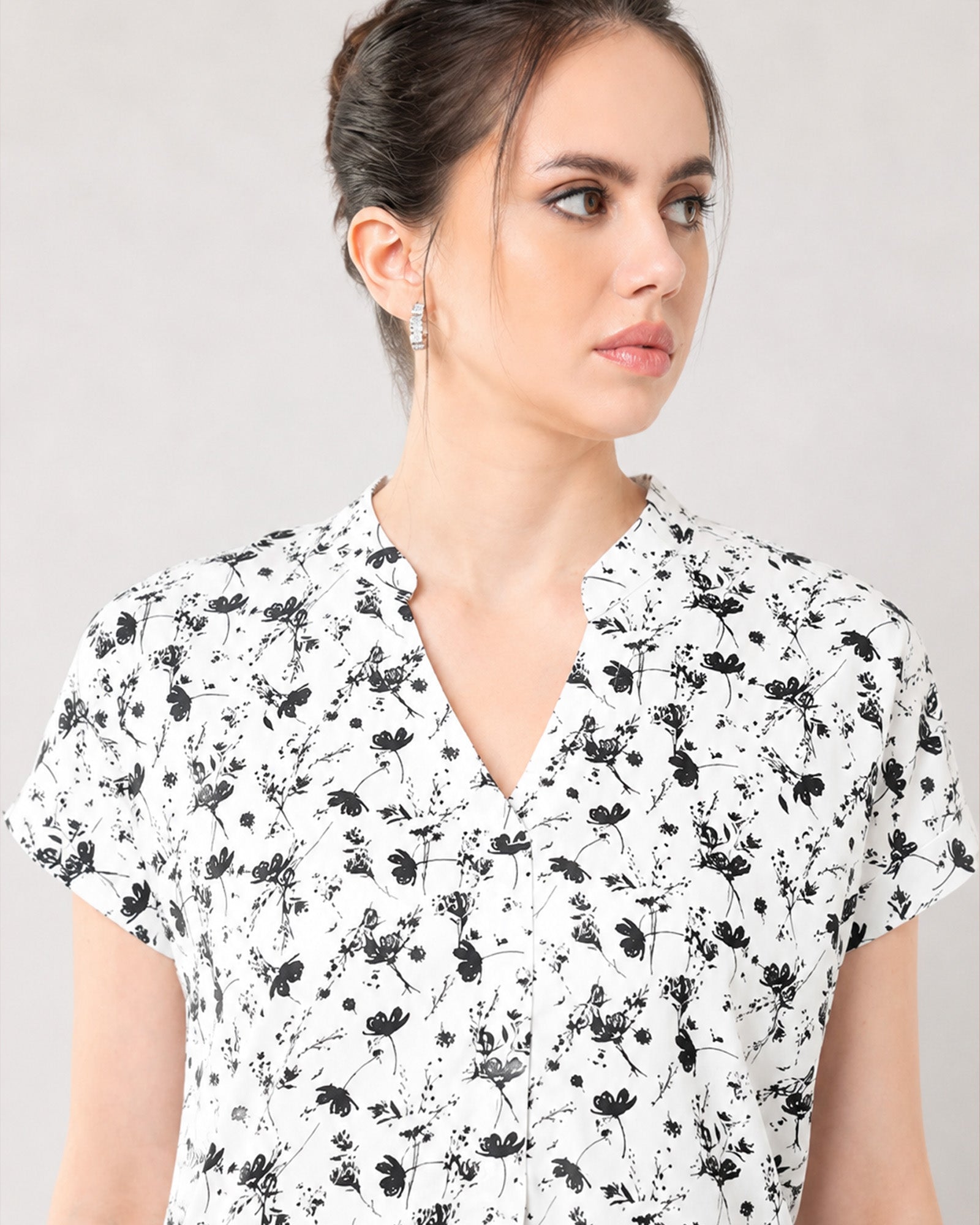 Close-up of Galia black and white floral top notched V-neckline and inverted centre pleat