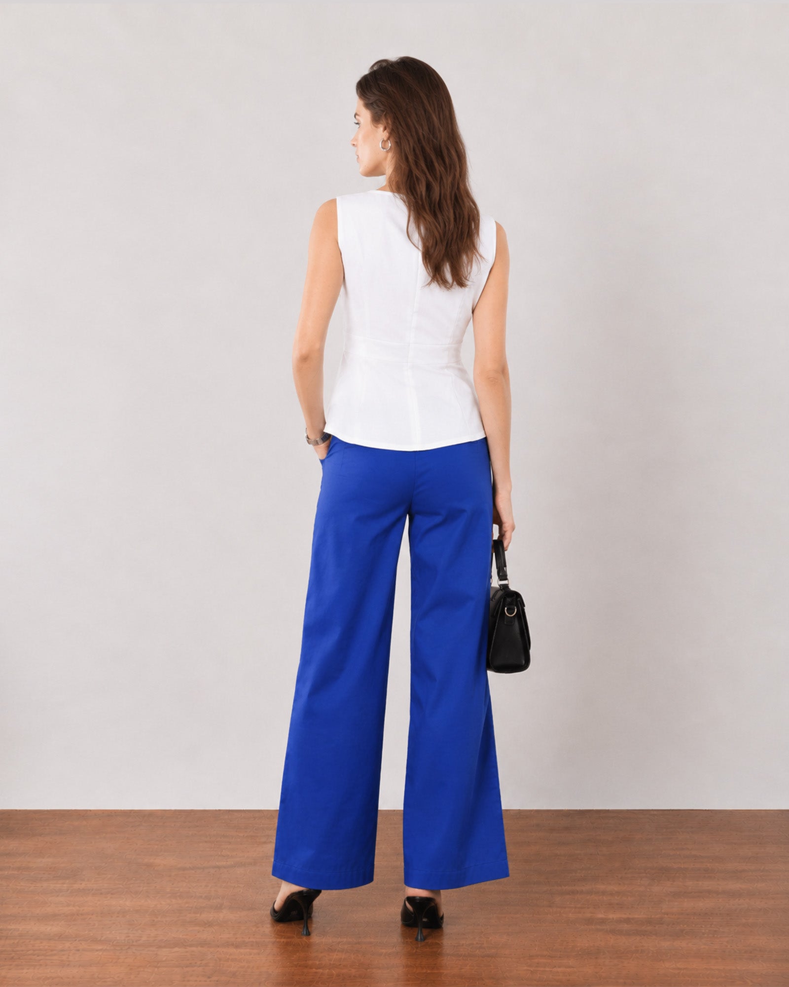 Gianna white linen top, back view showing panel seams and a softly flared hem