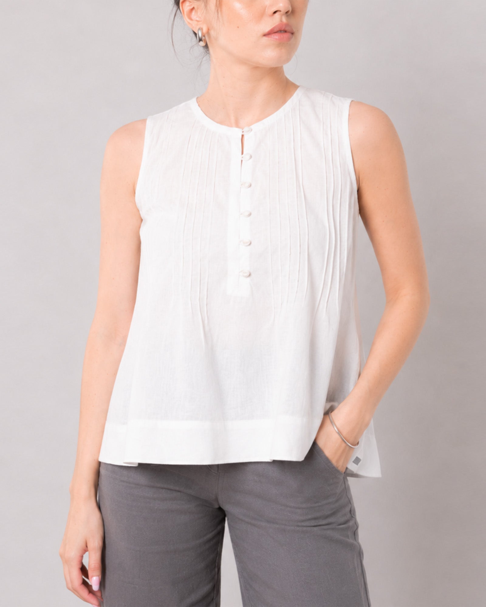 Gill white pin tuck top with a wide banded hemline and relaxed drape, front detail
