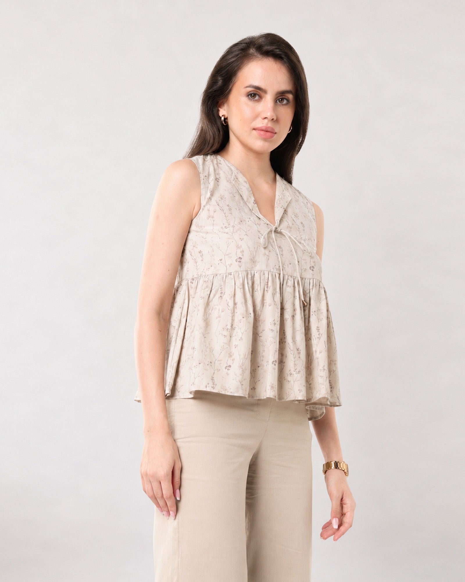 Gretchen beige sleeveless top in an Earthy Florals digital print, close-up of the voluminous peplum hem