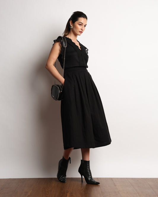 Hertha black lace V neck top worn with a black midi skirt, full-length angled view