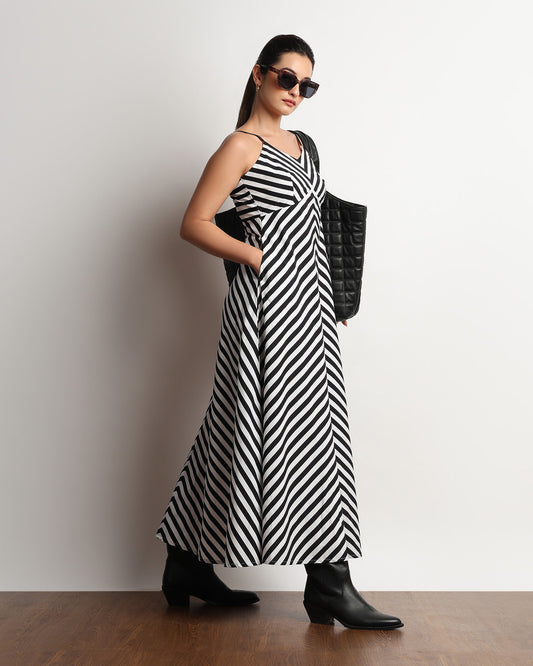 Hope black and white striped maxi dress worn with sunglasses and a tote, front view