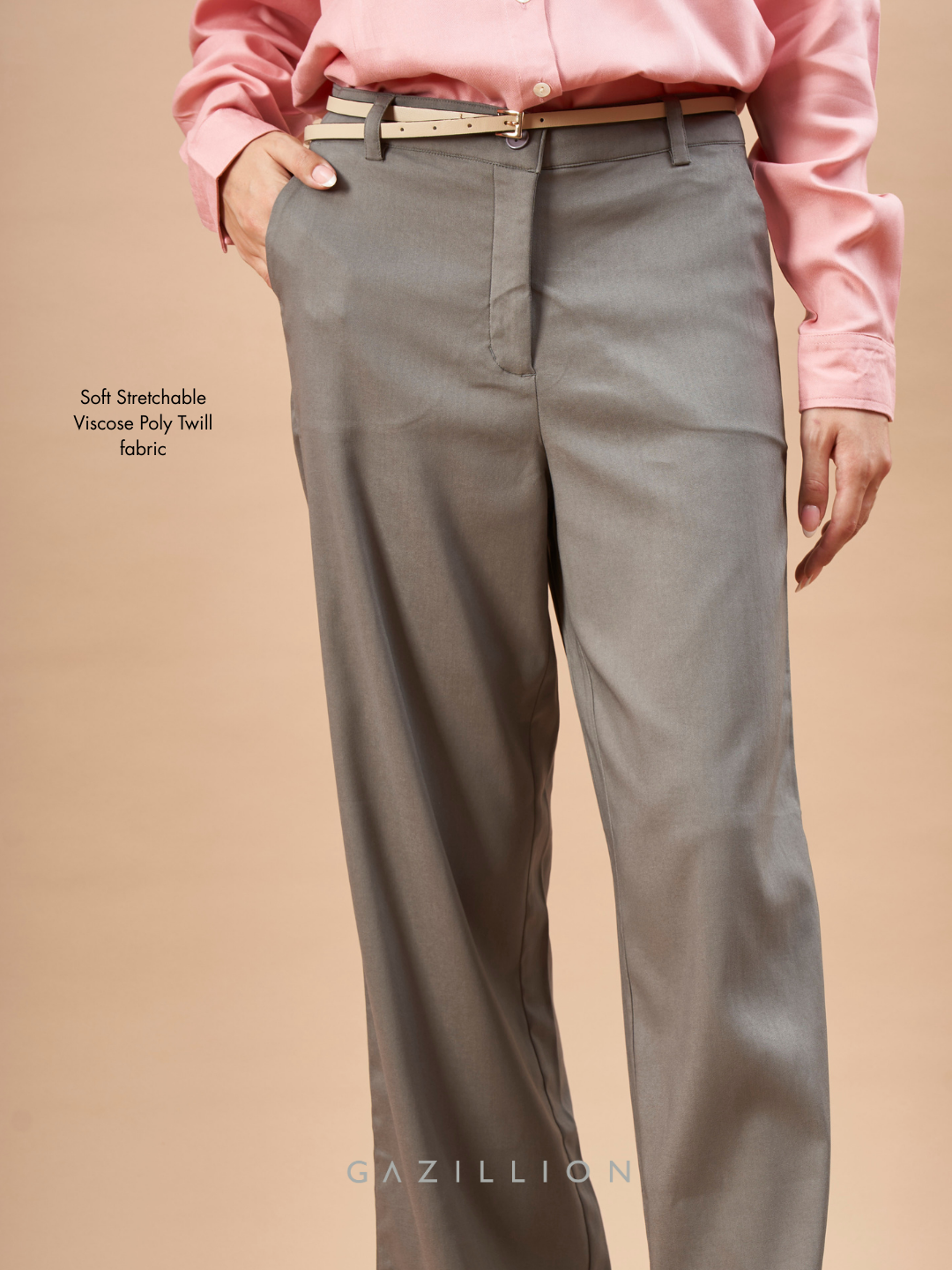 Person wearing gray pants and a pink shirt on a beige background