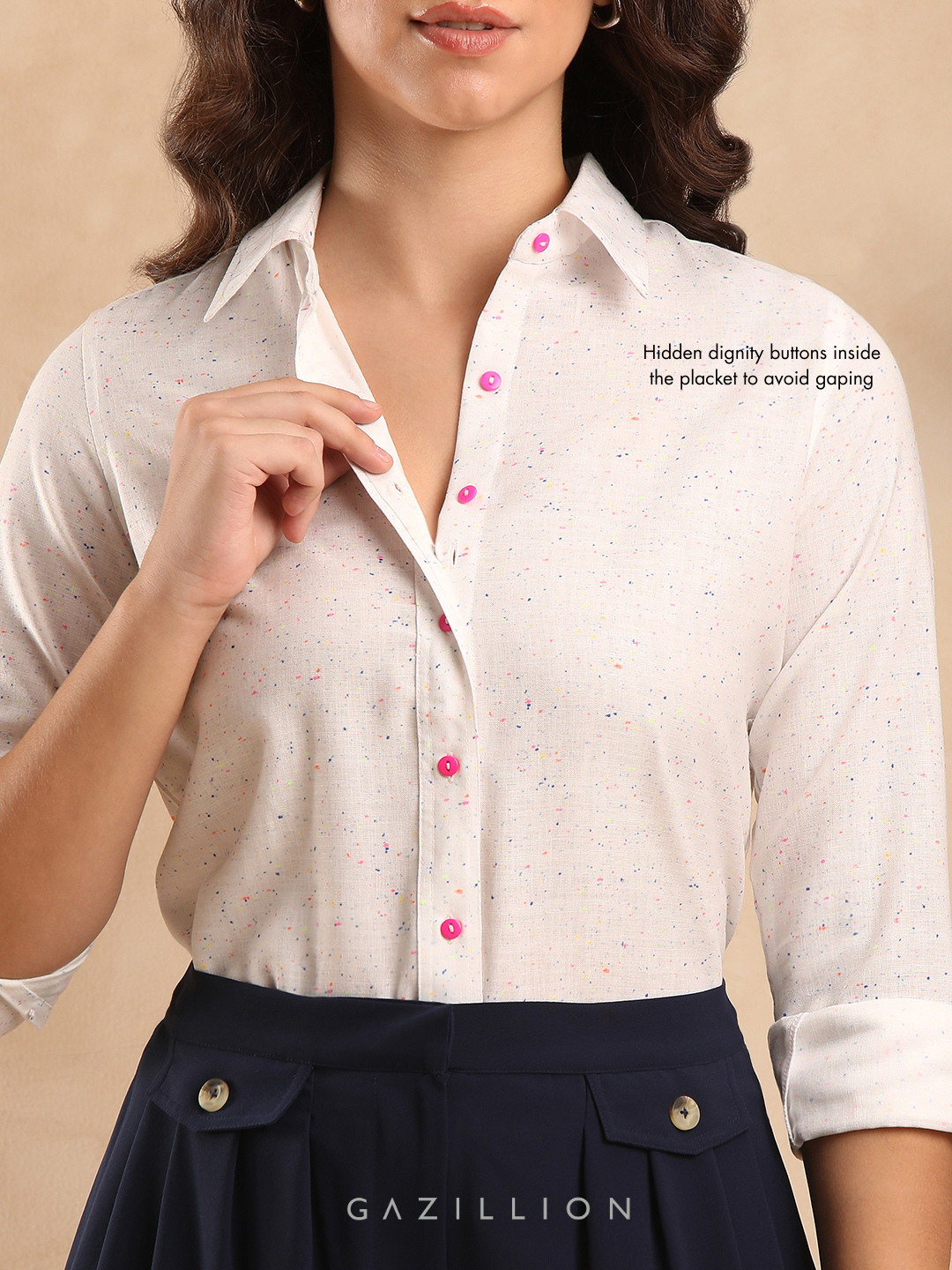 Woman wearing a white blouse with pink buttons.