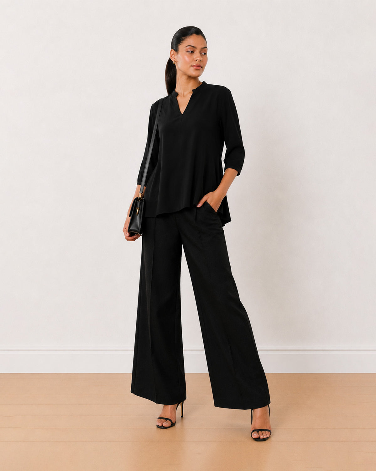 Alda black viscose plus size top, angled view with the long length and curved hem
