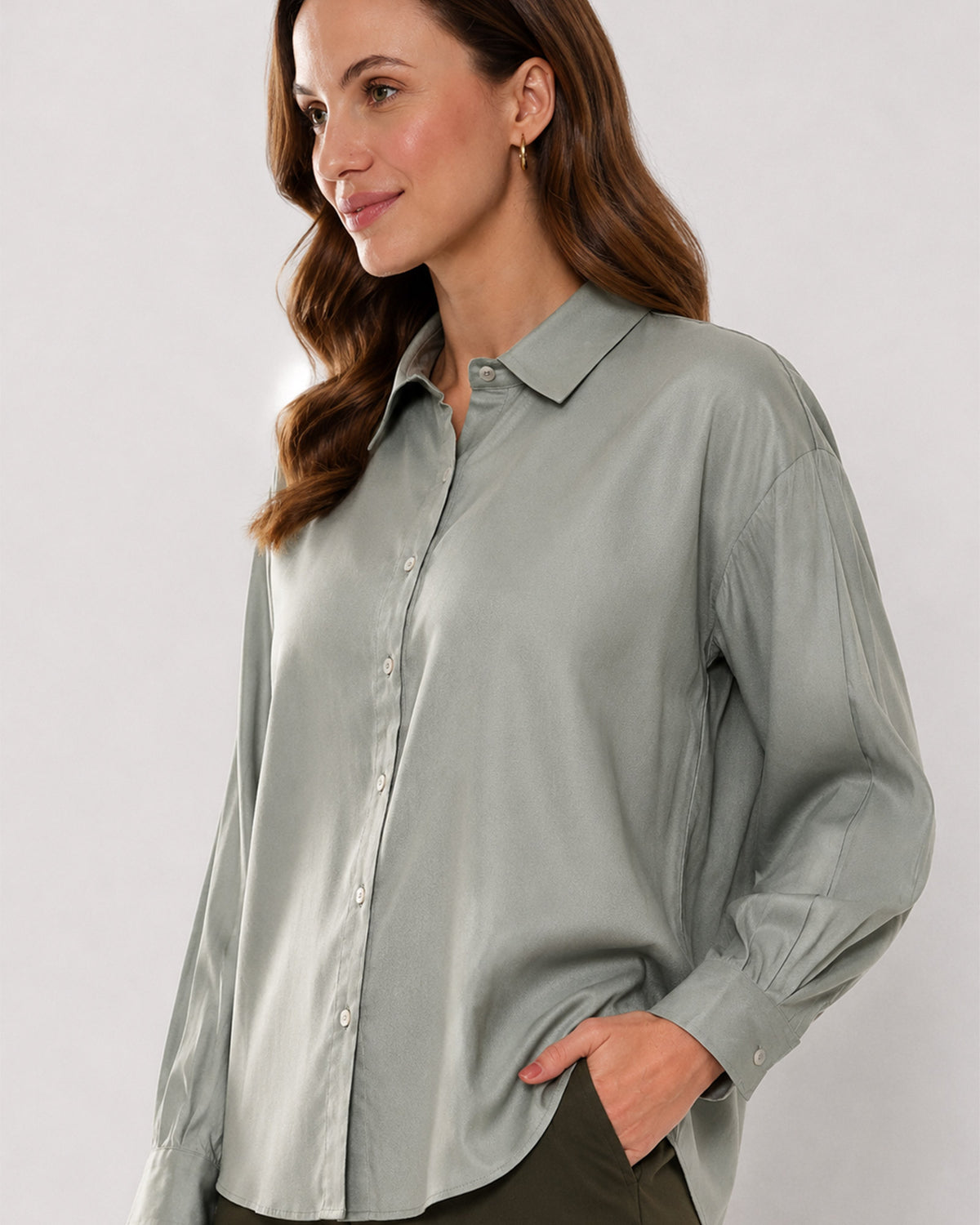 Angel sage green viscose shirt waist up front with the drop shoulder and curved hem