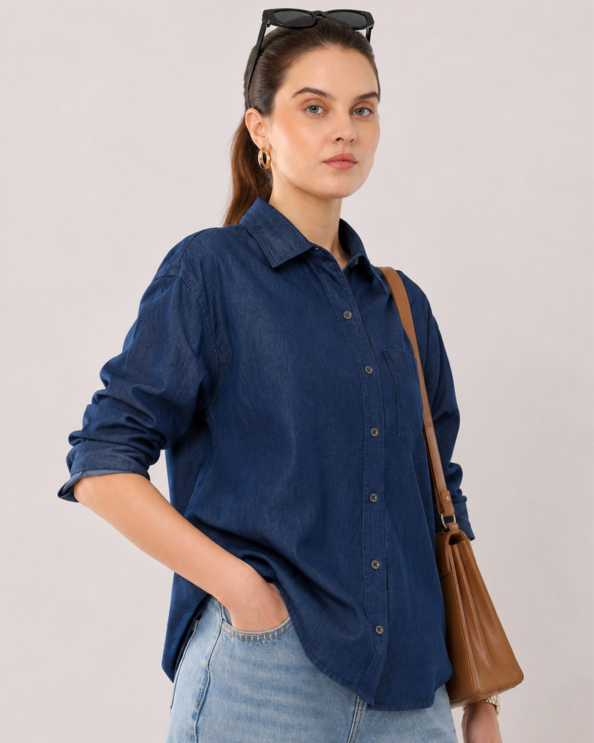 Athena 100% cotton denim oversized shirt waist up angled with rolled sleeves