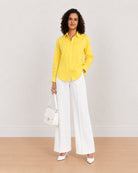 Bali bright yellow cotton poplin shirt worn loose, front view with the long curved hem