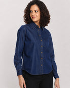 Banita medium blue denim shirt, angled front view with the long curved hem