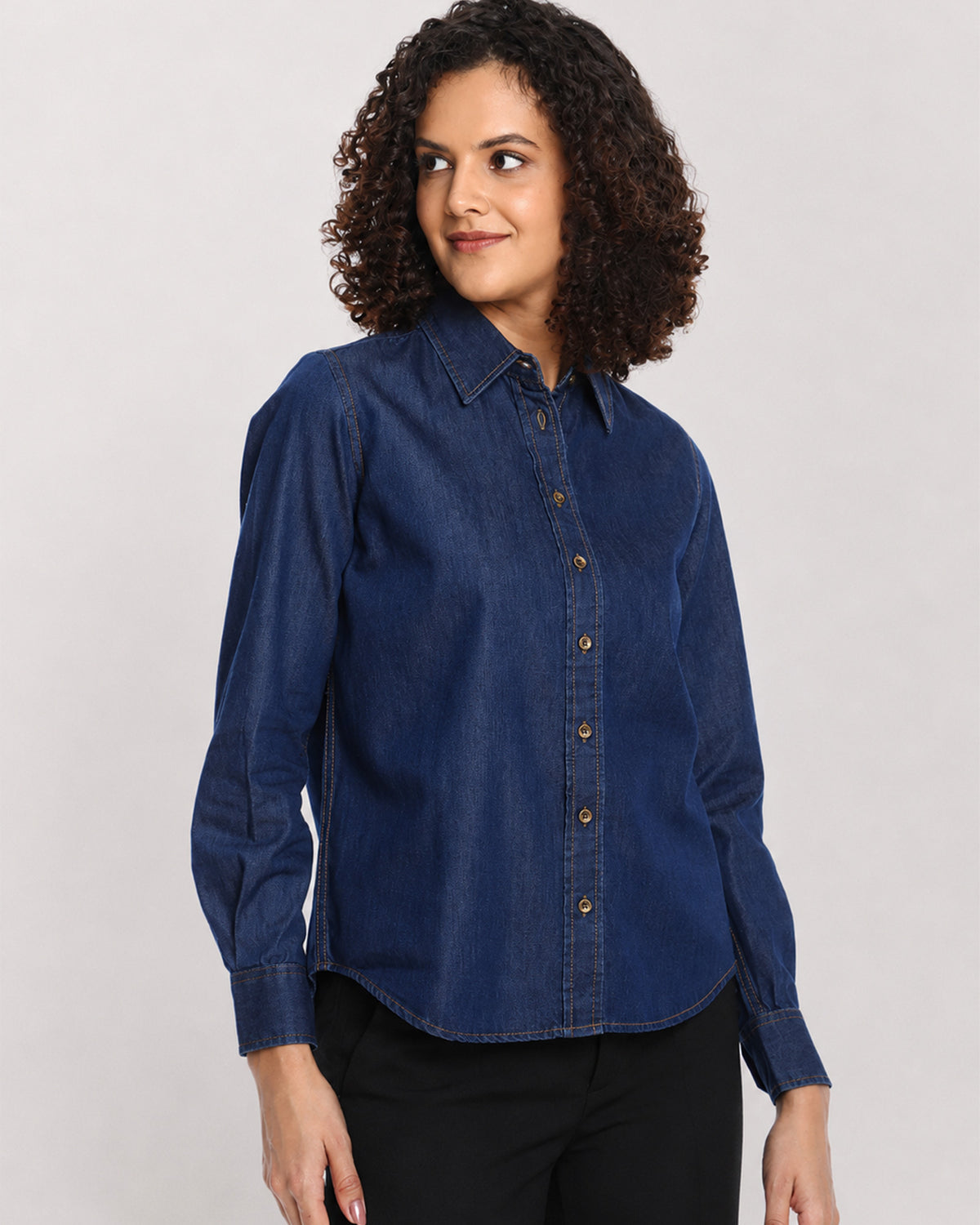 Banita medium blue denim shirt, angled front view with the long curved hem