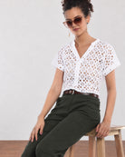 Belinda white schiffli cutwork lace top, seated waist up view with stand collar and V-neck