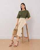 Bella beige 3/4th straight pants, seated angled view with loose fit and mid calf hem