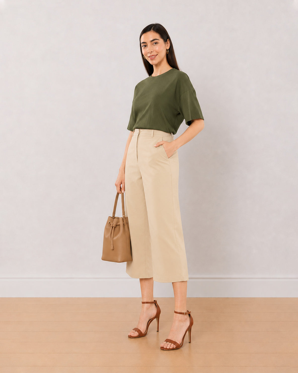 Bella beige loose fit 3/4th straight pants, angled front view walking in mid calf length