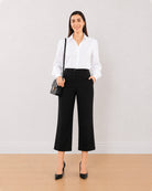 Bella black 3/4th straight pants front view with a hand in the side cross pocket
