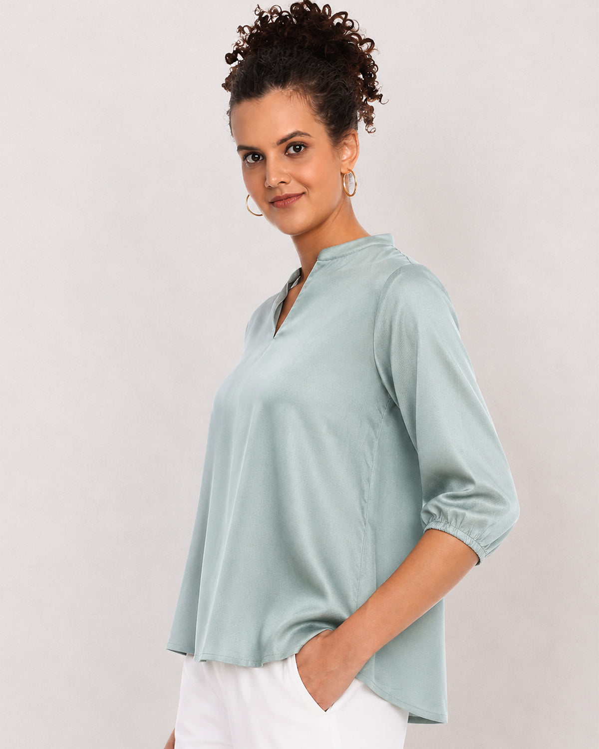 Bellina sage green viscose top, angled waist up view with boxy fit and extended shoulders