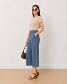 Bliss denim blue 3/4th straight pants, angled view with a hand in the side cross pocket