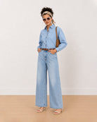 Brynn light blue denim shirt worn loose, front view with the curved frayed hem