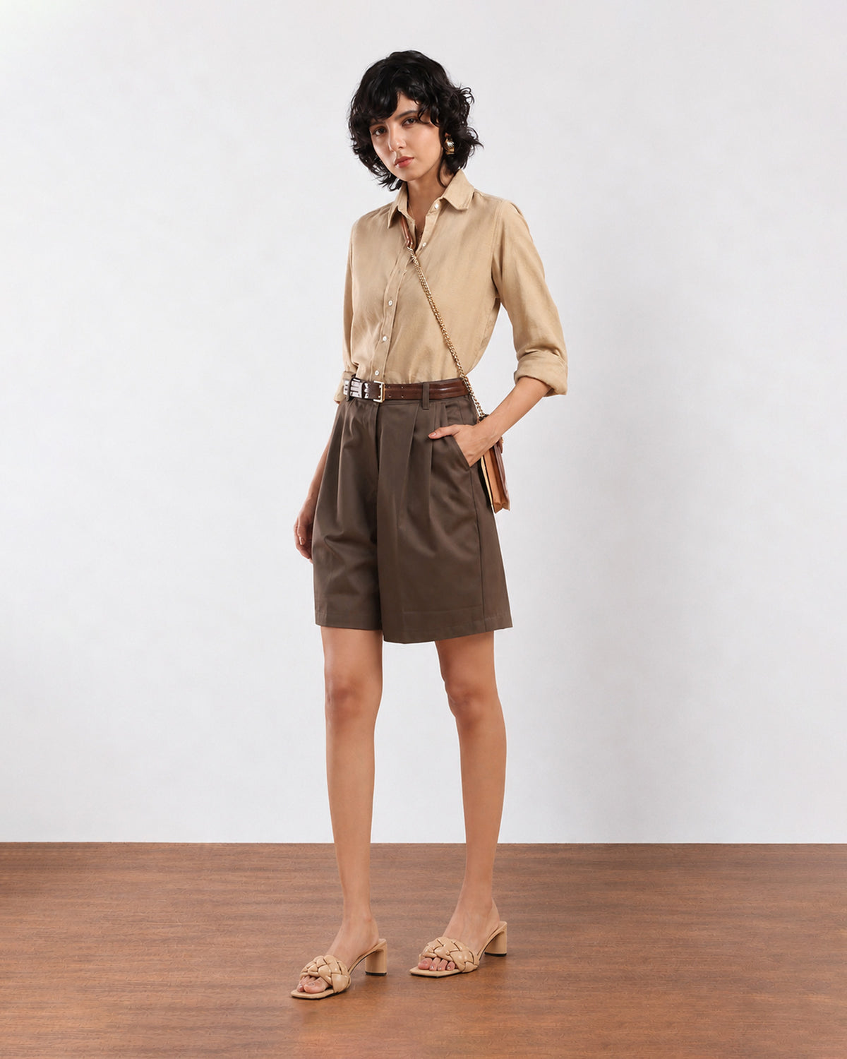 Camila olive green city shorts front view, loose fit with hand in the side cross pocket