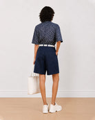 Back view of Carrie indigo blue denim city shorts showing back pocket and knee length hem
