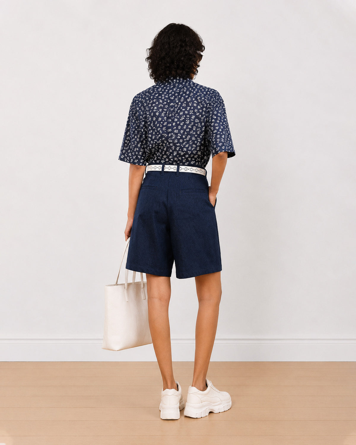 Back view of Carrie indigo blue denim city shorts showing back pocket and knee length hem