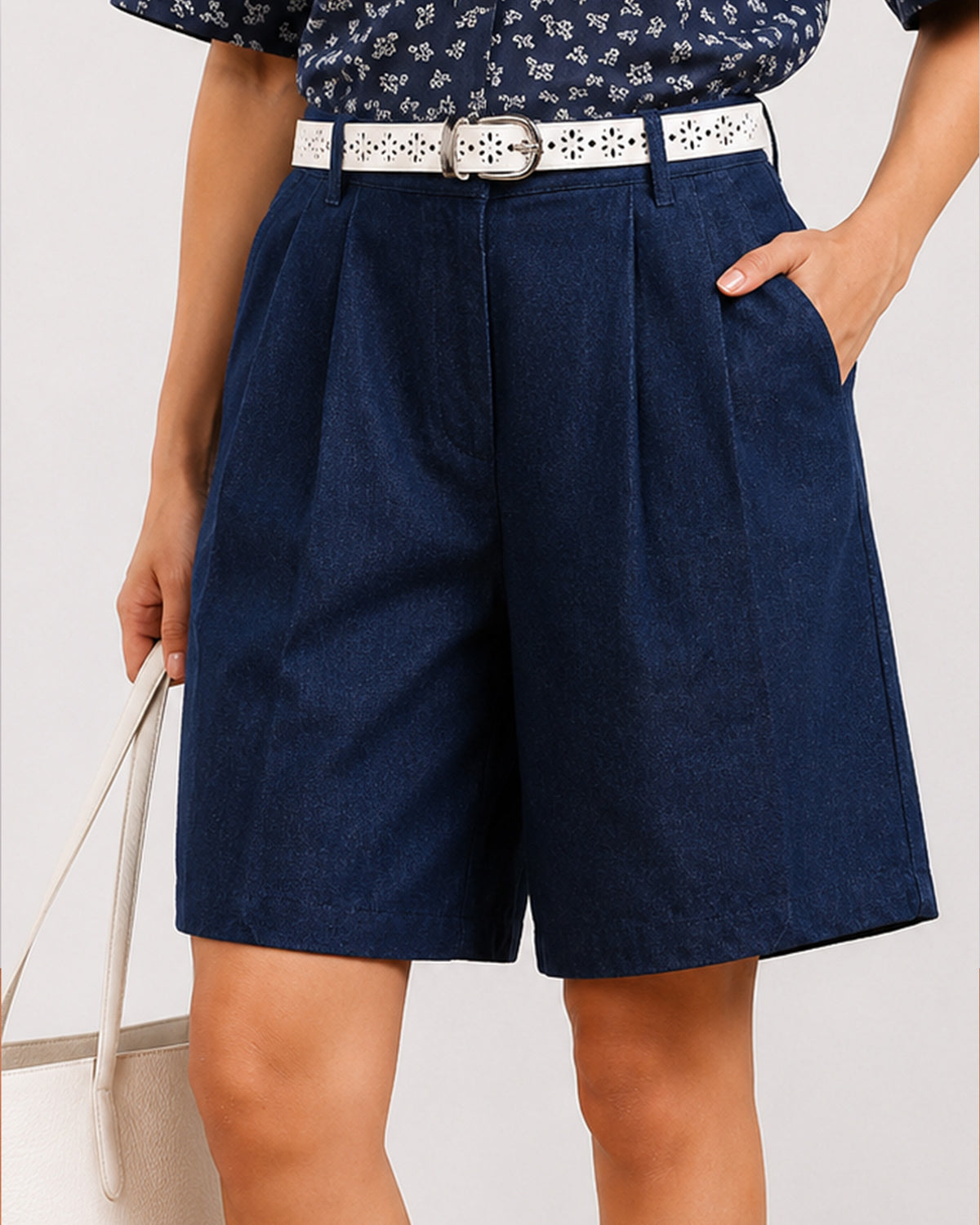 Close-up of Carrie indigo blue denim shorts showing front pleats, belt loops and side cross pocket