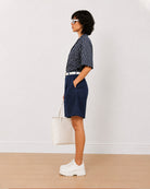 Side view of Carrie indigo blue 100% cotton denim bermuda shorts with high waisted fit