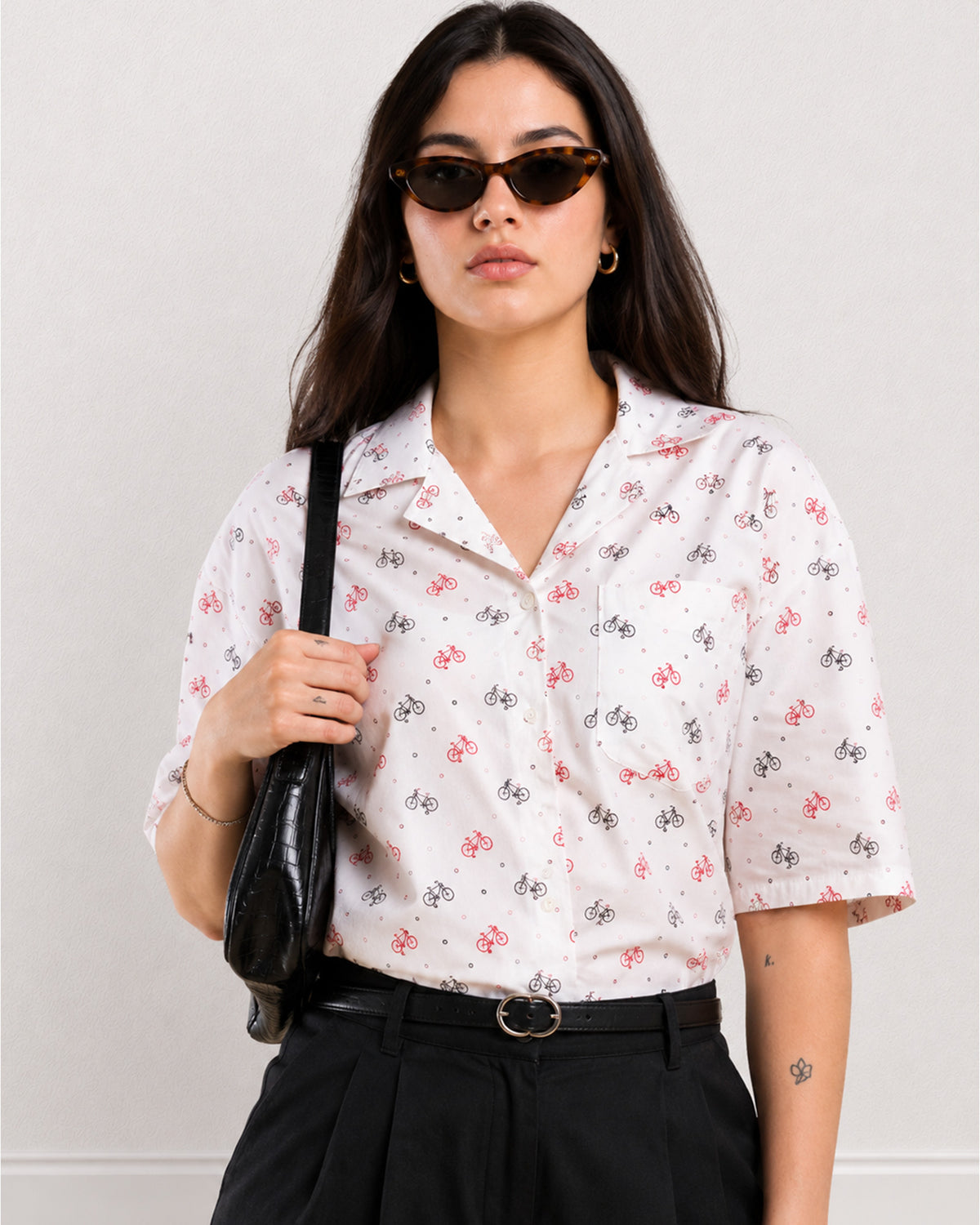 Close-up of Cecelia white shirt with red and black bicycle print and chest patch pocket
