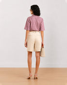 Back view of Celine beige bermuda shorts showing back welt pockets and belt loops