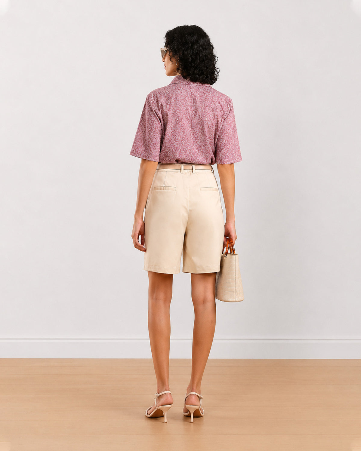Back view of Celine beige bermuda shorts showing back welt pockets and belt loops