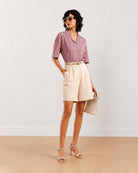 Celine beige poly cotton shorts front view with hand in the side cross pocket
