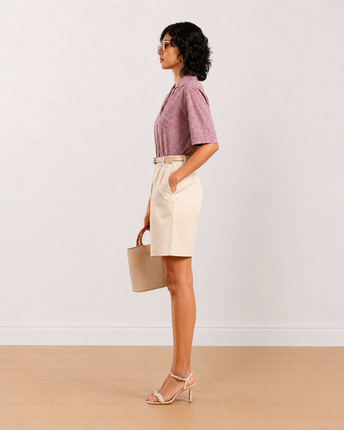 Side view of Celine beige knee length bermuda shorts with a high waisted loose fit