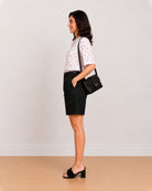 Side view of Celine black bermuda shorts showing loose fit and knee length hem