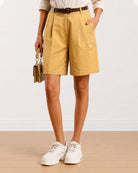 Close-up of Celine camel beige shorts showing front pleats and knee length hem