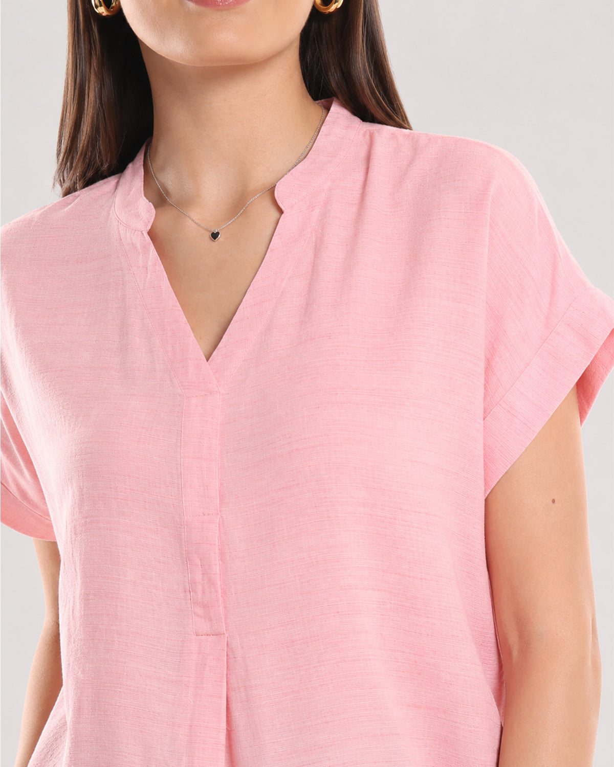 Close-up of Chloe pink top stand collar with V-neck and centre front pleat in soft rayon