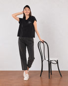 Gazillion Christiana black loose cotton t-shirt with Wiser Kinder Bolder pocket print, full-length front view