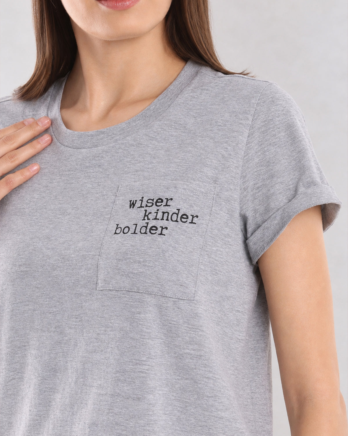 Close-up of Christiana grey melange t-shirt pocket with Wiser Kinder Bolder print