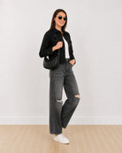 Dani black cropped trucker jacket with epaulet cuff tabs and metallic buttons, angled front view