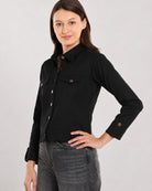 Dani black cropped trucker jacket showing the chest pocket flaps and metallic front buttons