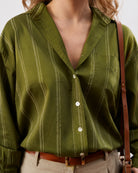 Close-up of Darlina olive green shirt chest patch pocket, stripes and dignity buttons