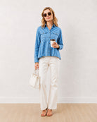 Delta light blue denim peplum shirt, full length walking front view with full sleeves