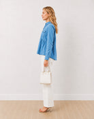 Delta light blue denim peplum shirt, side profile view with gathers at the waist
